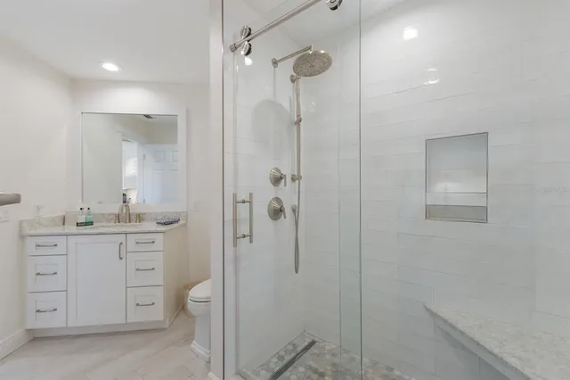 a bathroom with a granite countertop sink toilet and shower