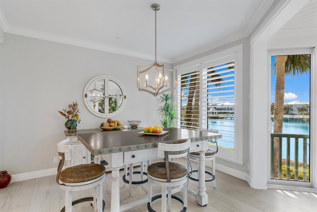 799 Beach View Drive Boca Grande, FL 33921 - Photo 7 of 77 a view of a dining room with furniture a chandelier and wooden floor