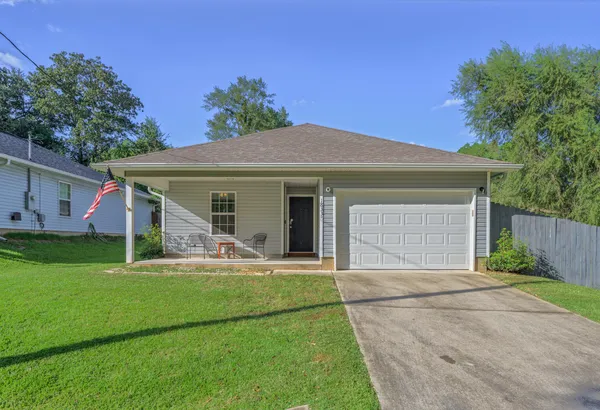 a front view of a house with a garden and yard