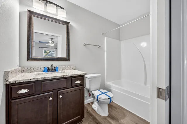 a bathroom with a granite countertop sink a toilet and a mirror
