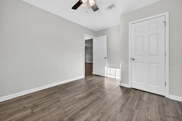 a view of an empty room with wooden floor