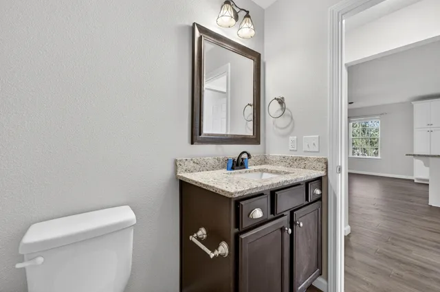 a bath room with a toilet a sink and a mirror
