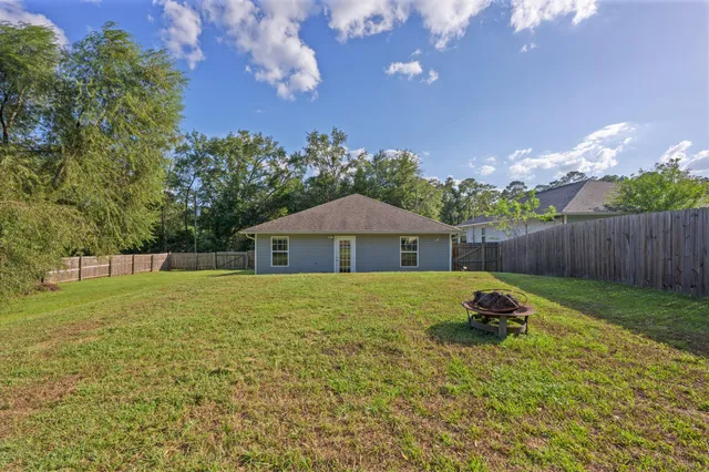 a backyard of a house with table and chairs
