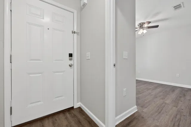 a view of empty room with wooden floor