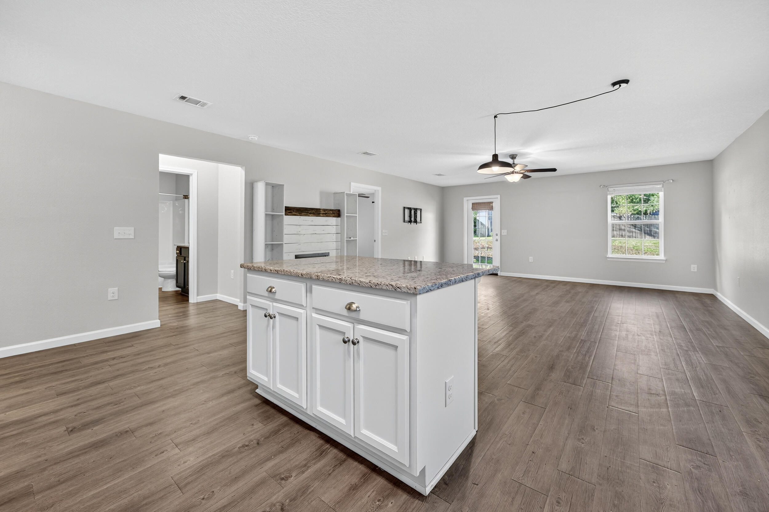 1833 Gainer Avenue Baker, FL 32531 - Photo 9 of 43 a view with granite countertop kitchen island wooden floors white cabinets and stainless steel appliances