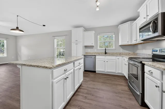 a kitchen with granite countertop a sink and cabinets