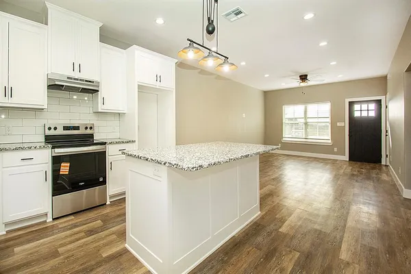 a kitchen with stainless steel appliances granite countertop a stove and a refrigerator