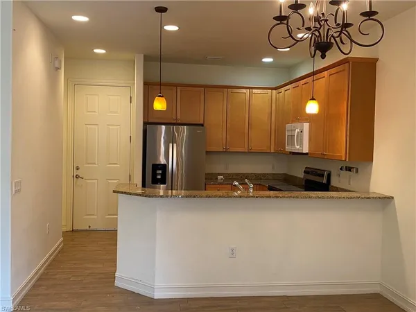 a view of a kitchen with a sink and chandelier