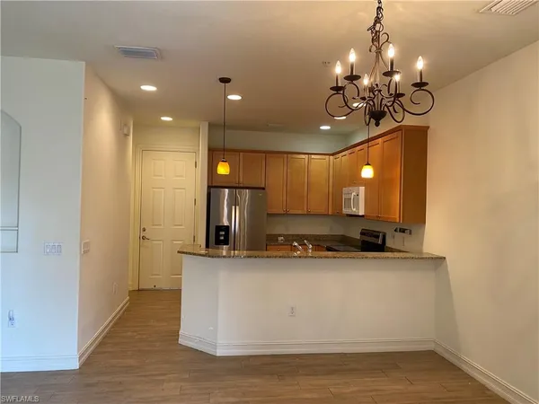 a view of a kitchen with a sink and chandelier
