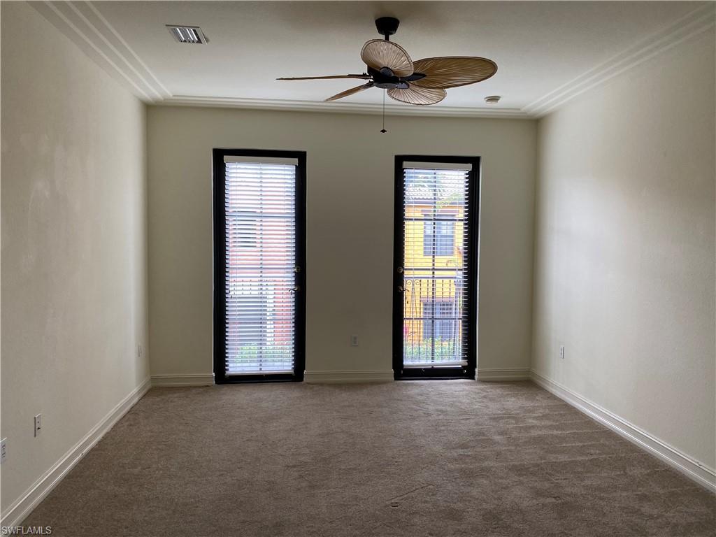 9151 Delano Street, Unit 9702 Naples, FL 34113 - Photo 7 of 14 an empty room with chandelier fan and windows