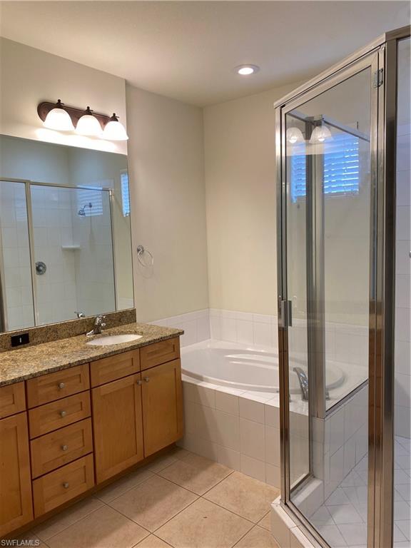 9151 Delano Street, Unit 9702 Naples, FL 34113 - Photo 8 of 14 a bathroom with a double vanity sink and mirror with bathtub