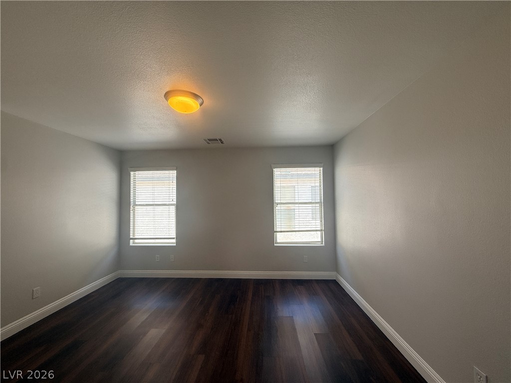 11953 Fairfax Ridge Street Las Vegas, NV 89183 - Photo 24 of 32 Well-lit room features rich dark wood flooring and ample natural light through dual windows.