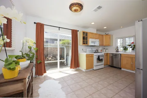 a kitchen with a refrigerator a stove top oven a sink and a large window
