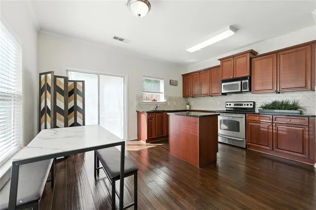 a kitchen with granite countertop stainless steel appliances and wooden cabinets