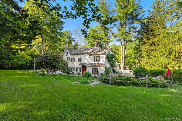 a view of a house with a big yard and large trees