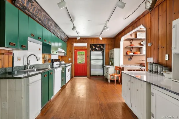 a large kitchen with stainless steel appliances granite countertop a lot of counter space and a wooden floors