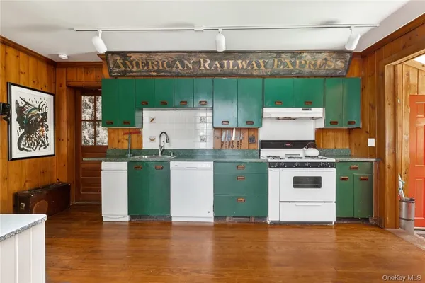 a kitchen with granite countertop a stove and a wooden floors