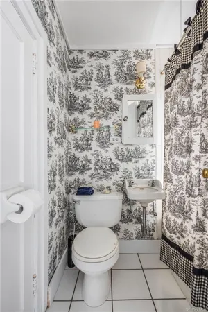 a bathroom with a toilet and a shower curtain