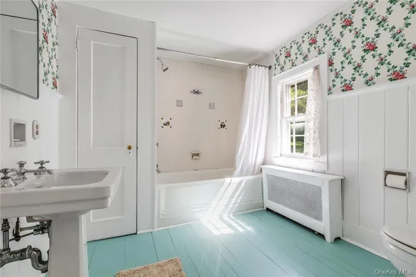 a bathroom with a sink a bathtub and a window