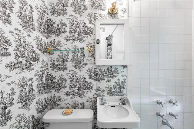 a bathroom with a toilet sink and mirror