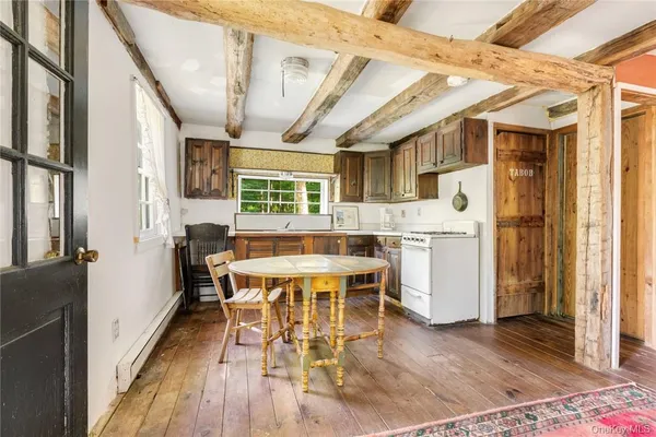 a kitchen with stainless steel appliances a dining table chairs refrigerator and sink