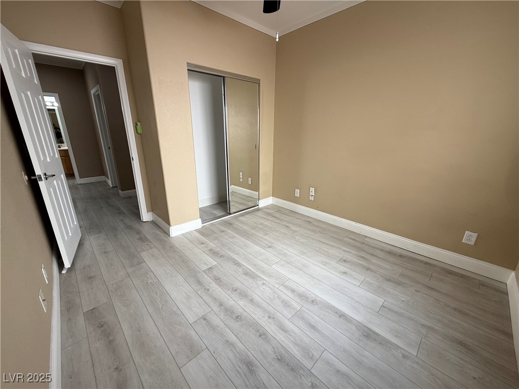 7062 Russell Ranch Avenue Las Vegas, NV 89113 - Photo 30 of 32 Unfurnished bedroom with a closet, baseboards, and light wood-type flooring