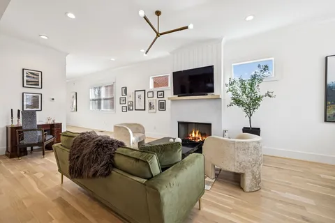 a living room with furniture a fireplace and flat screen tv