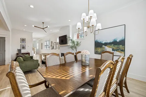a dining room with furniture a chandelier and wooden floor