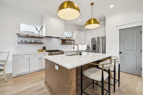 a view of a hallway with wooden floor and staircase
