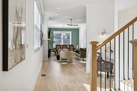 a view of a dining room with furniture a chandelier and wooden floor