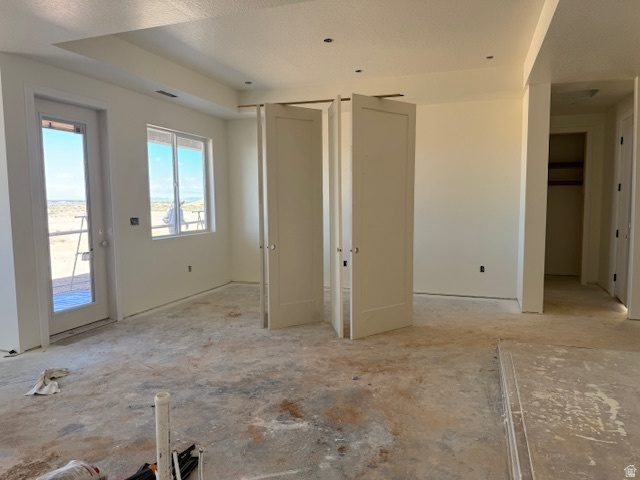 5005 North 75 East Enoch, UT 84721 - Photo 15 of 37 Unfurnished bedroom featuring access to outside, a tray ceiling, and a textured ceiling