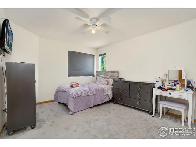 a bedroom with a bed dresser and a flat tv screen