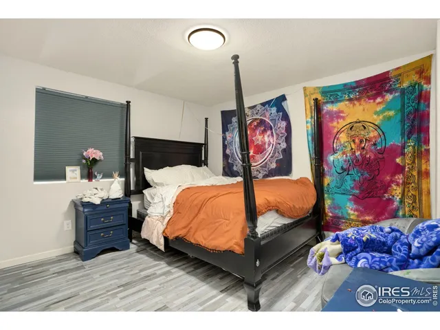 a bedroom with a bed dresser and painting on the wall