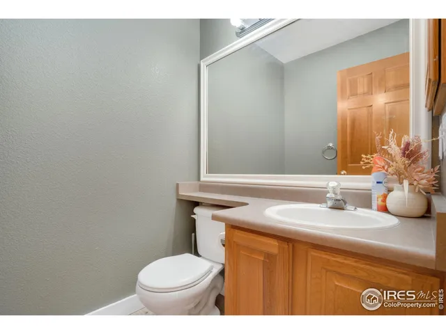 a bathroom with a granite countertop toilet sink and mirror