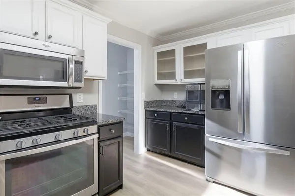 a kitchen with stainless steel appliances granite countertop a stove microwave and refrigerator