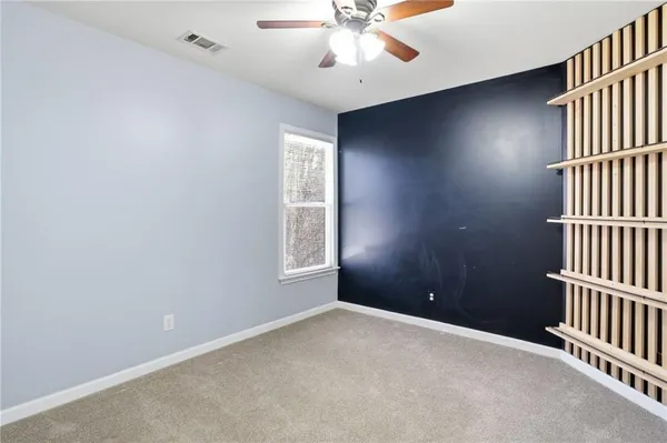 an empty room with windows and fan