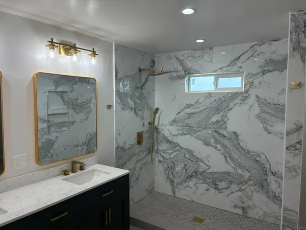a bathroom with a sink vanity granite and shower