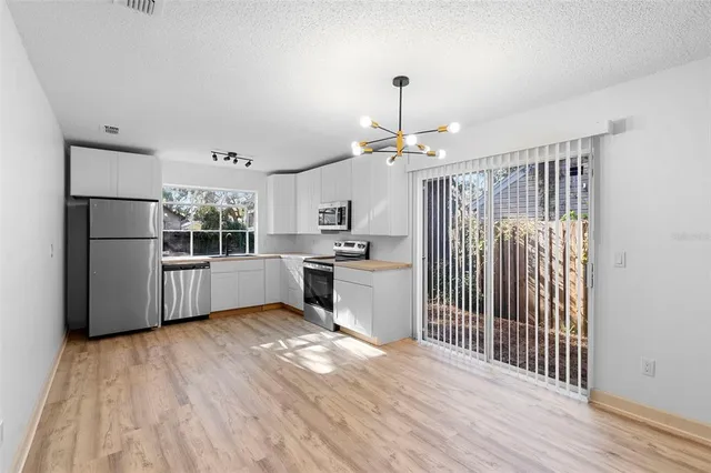 a kitchen with stainless steel appliances a refrigerator and wooden floor