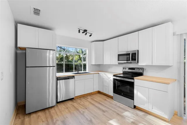 a kitchen with stainless steel appliances granite countertop a refrigerator a stove a sink and a microwave