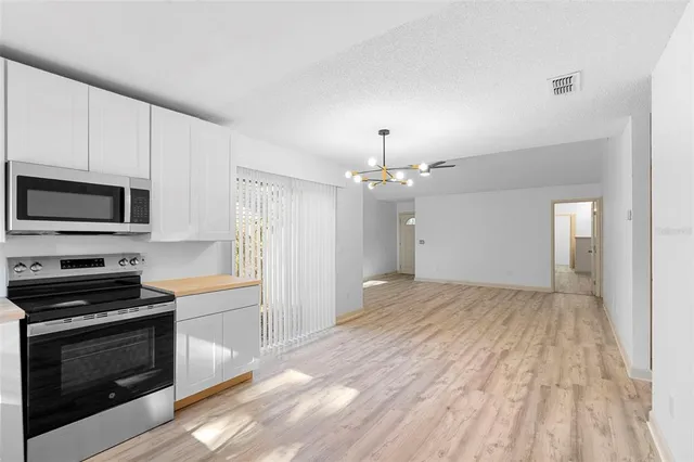 a view of a kitchen with a sink stove refrigerator and microwave