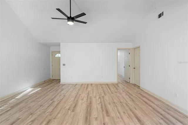 a view of a room with wooden floor and a ceiling fan