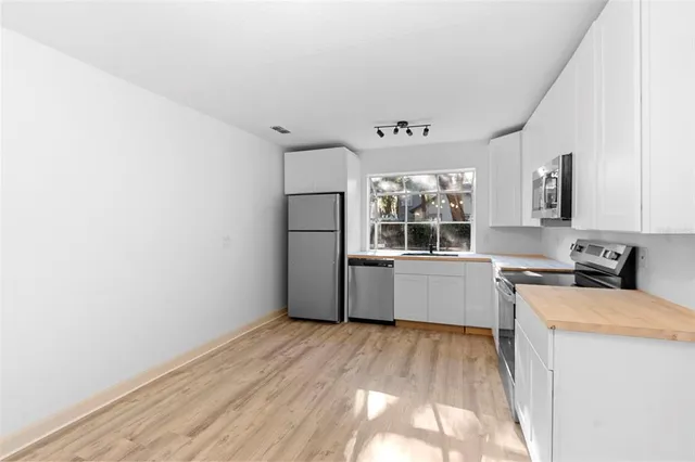 a kitchen with stainless steel appliances a refrigerator and a stove top oven