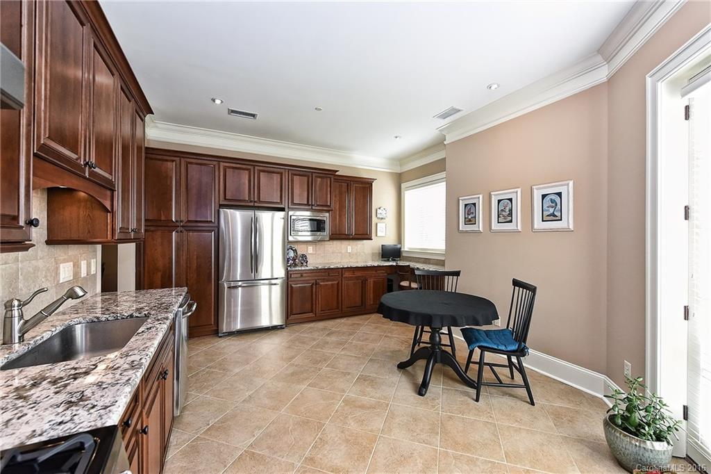 2823 Providence Road, Unit 228 Charlotte, NC 28211 - Photo 11 of 24 a kitchen with refrigerator cabinets dining table and chairs
