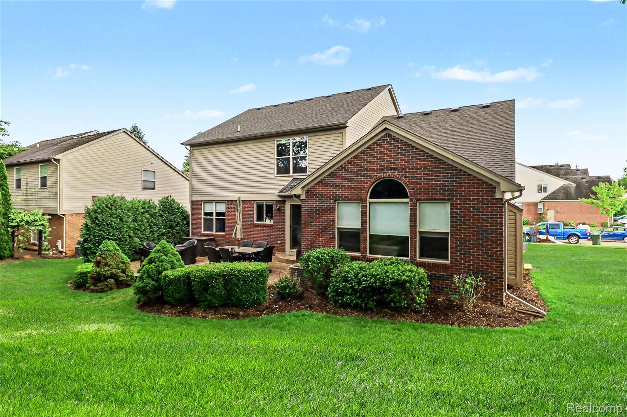 2548 Empire Court Rochester, MI 48309 - Photo 38 of 40 Expansive green lawn with established landscaping, featuring a brick and siding exterior with a patio area