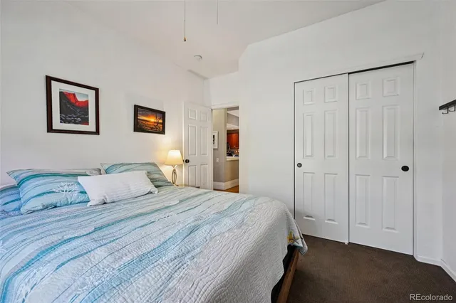 a bedroom with a bed and painting on the wall