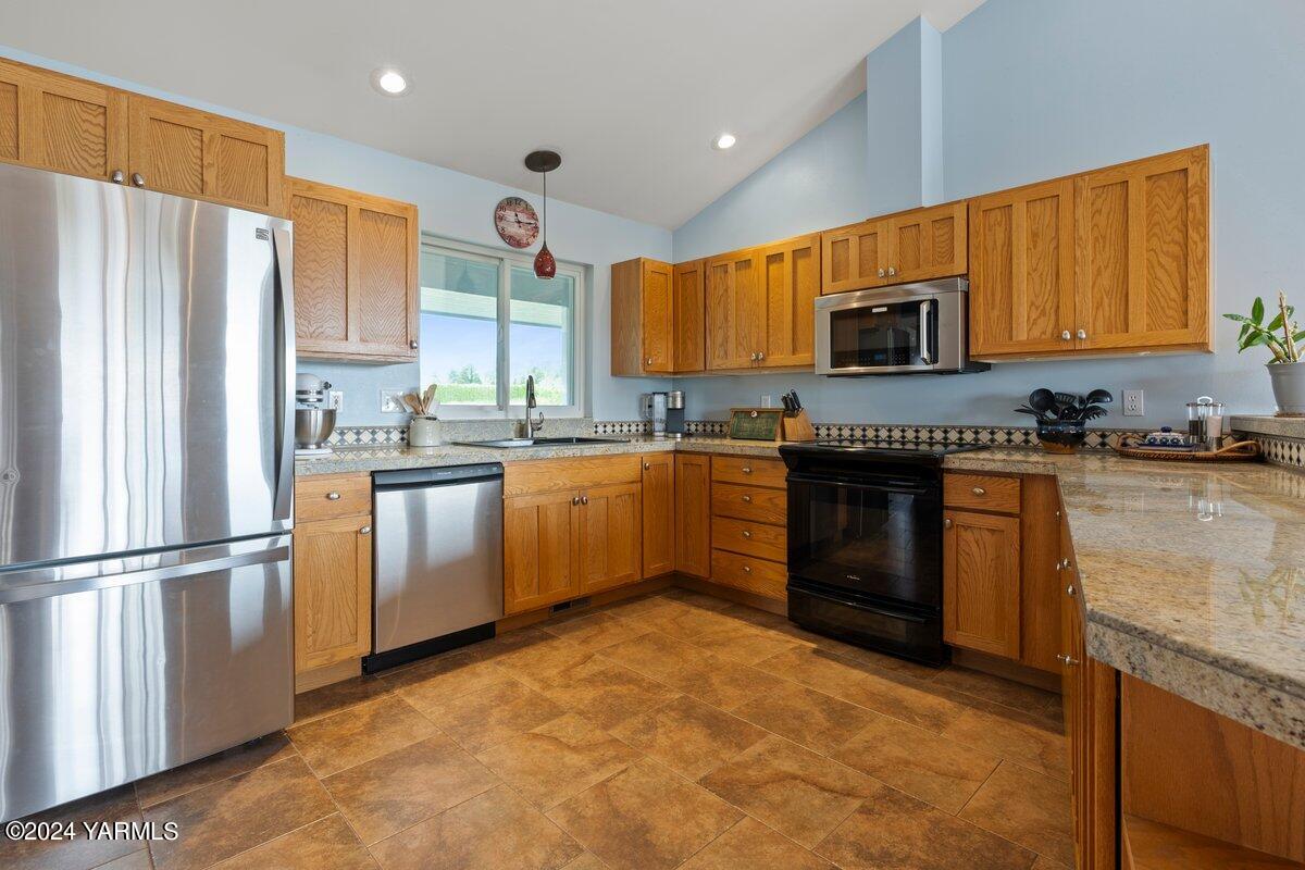 1084 Thompson Road Cowiche, WA 98923 - Photo 5 of 21 a kitchen with stainless steel appliances granite countertop a stove top oven a sink dishwasher a refrigerator and cabinets with wooden floor