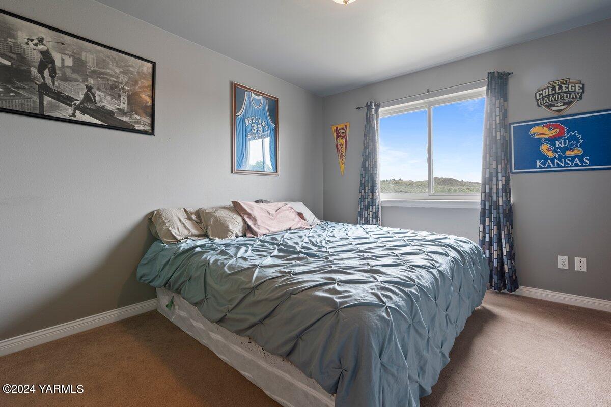 1084 Thompson Road Cowiche, WA 98923 - Photo 10 of 21 a bed sitting in a bedroom next to a window