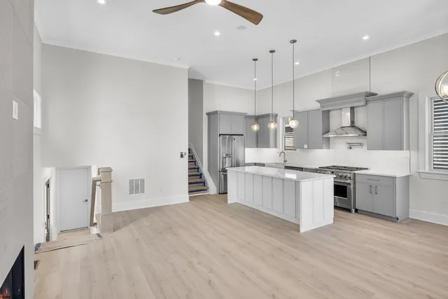a large kitchen with kitchen island a sink a stove a refrigerator and white cabinets