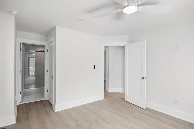 an empty room with wooden floor and mirror