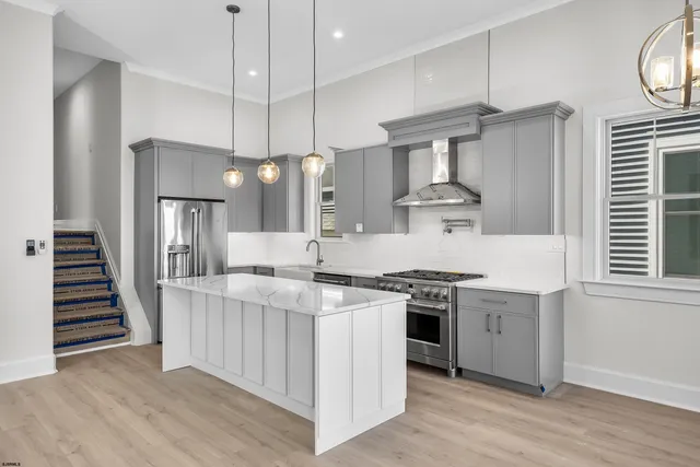 a kitchen with stainless steel appliances granite countertop a stove and a wooden floors